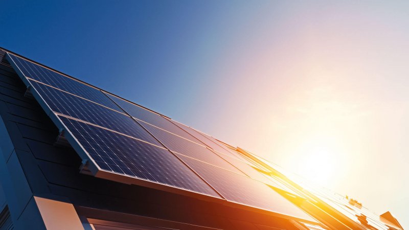 Solarmodule auf einem Dach im Sonnenuntergang